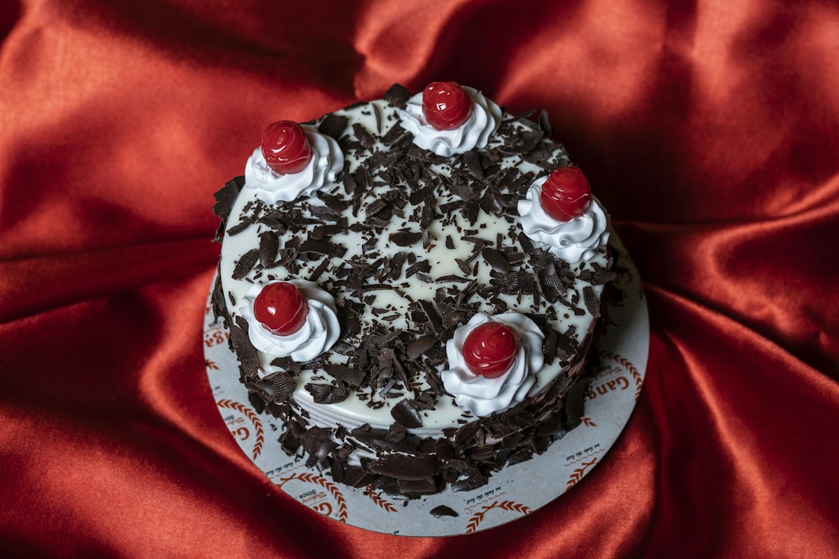 Black forest cake topped with cream and cherries